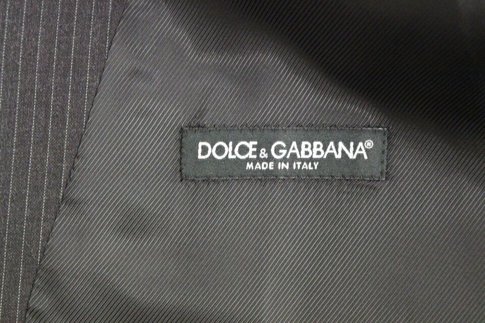Dolce & Gabbana Elegant Gray Striped Dress Vest made of 100% wool and featuring a single-breasted design with adjustable back waist strap for a tailored fit and a polished button closure, perfect for layering over professional or formal attire